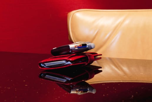 Woman executive's red wallet and cell phone positioned for an important call 