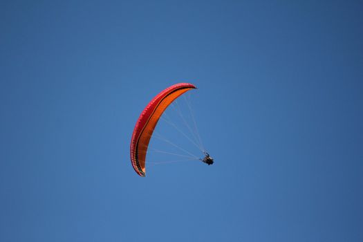 paragliding red and orange and sky blue