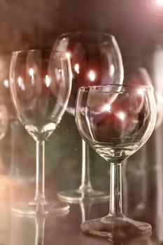 Still-life from crystal glasses and glass bottles against a dark background