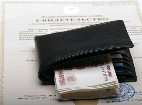 The certificate of the individual businessman, leather wallet and pack of money.