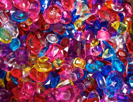 A field of brightly colored plastic jewels which are pink, red, blue and yellow in color