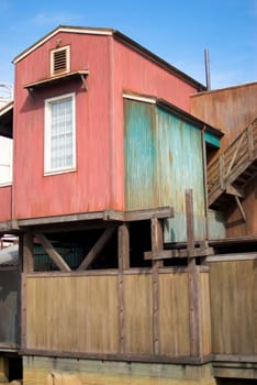 A vertical shot of an old, rundown cannery row building with a single window