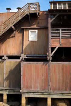 A vertical shot of an old, rundown cannery row building with a single window