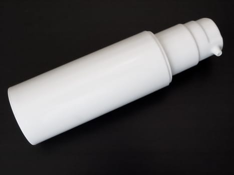 white bottle of spray against black background