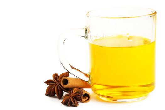 yellow tea with cinnamon sticks and star anise on white background