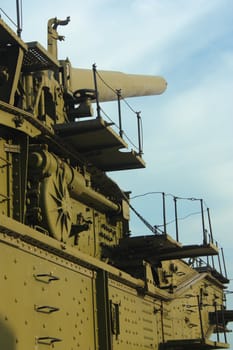 Gun on an armored train on a background of white blue sky