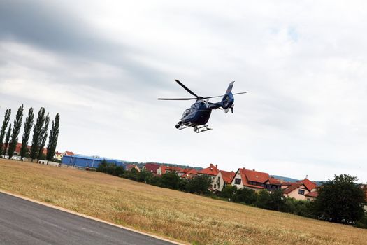 Blue and silver police helicopter flying above