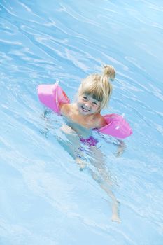 Young girl in a swimming-pool with water wings