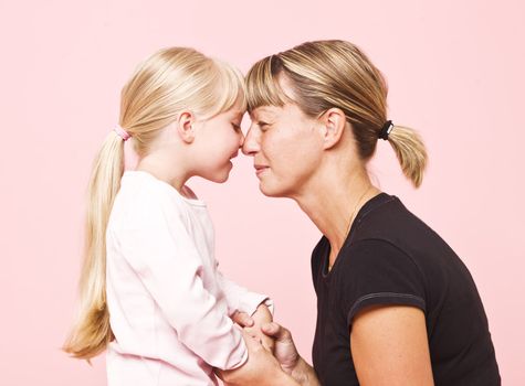 Mother and daughter on pink background