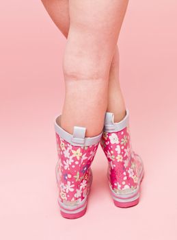 Girl with boots on pink background
