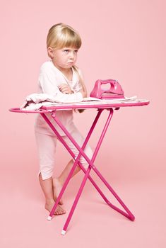 Angry girl with an iron on pink background