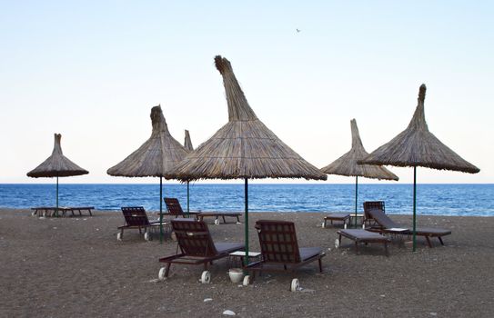 Shade hut and beach chairs  on sand sea coast at evening