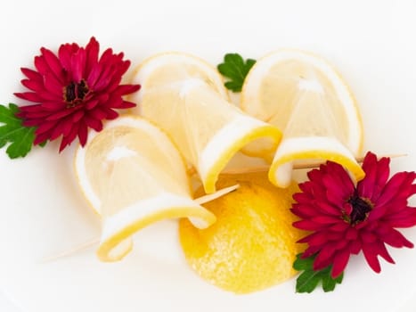  plate with lemon and flowers against the white background