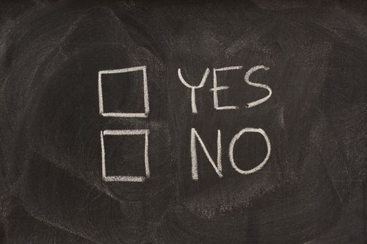 yes and no checkboxes sketched with white chalk on blackboard with eraser smudges
