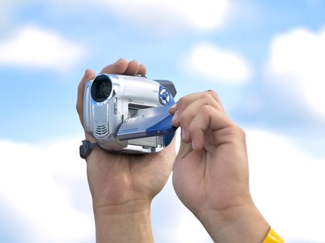 man hands hold camera against cloudy sky