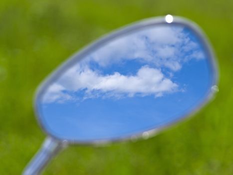 blue cloudy sky reflection in the motorcycle mirror