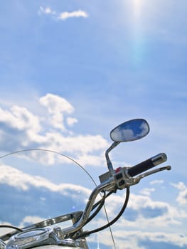 motorcycle handle with mirror against cloudy sky