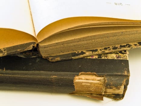 Old open book with closed book at the white table