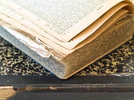 Old open book with closed book at the white table