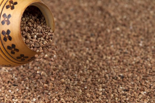 buckwheat falls from a wooden pot