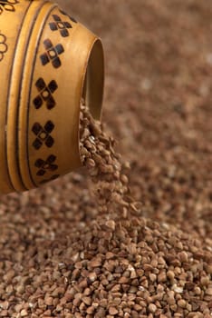 buckwheat falls from a wooden pot