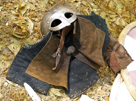 knight metal helmet near the stripped shield 