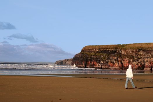 the storm waves crashing in on ballybunion beach ireland with walker