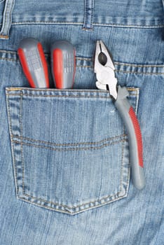 two screwdriver and pliers in the pocket of jeans