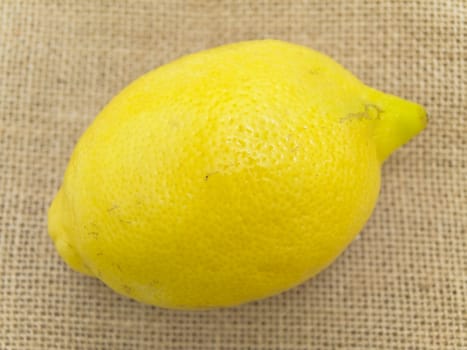 Single lemon at the brown linen