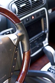 Salon expensive car. Leather-covered steering wheel close-up. Focus on the steering wheel, blurred.