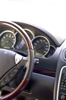 Salon expensive car. Leather-covered steering wheel close-up. Focus on the steering wheel, blurred.