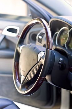 Salon expensive car. Leather-covered steering wheel close-up. Focus on the steering wheel, blurred.