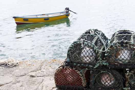 Detail of crab cages with small vessel in the background.