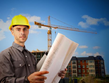 Young architect wearing a protective helmet in front of a building site