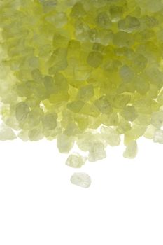 yellow bath salt crystals over white background