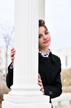 teen beautiful girl standing behind white column
