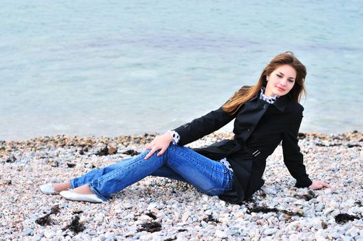 thoughtful girl relaxing on the beach in spring time
