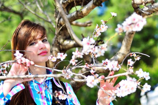 sweet teen standing close to the firl spring blossom