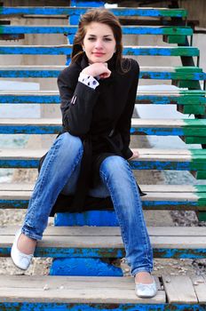 sweet teen girl  sitting on the stairs on the beach