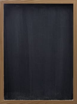 blank blackboard in wooden frame, white chalk eraser smudges