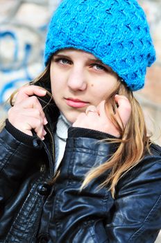 teen girl wearing blue hat and leather jacket