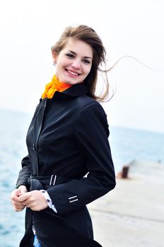 teen smiling girl in windy day near the sea