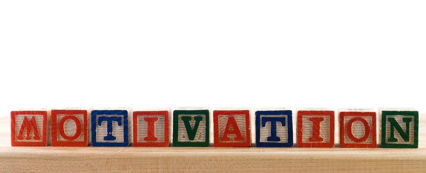 The word motivation spelled using colored baby letter blocks, isolated against a white background