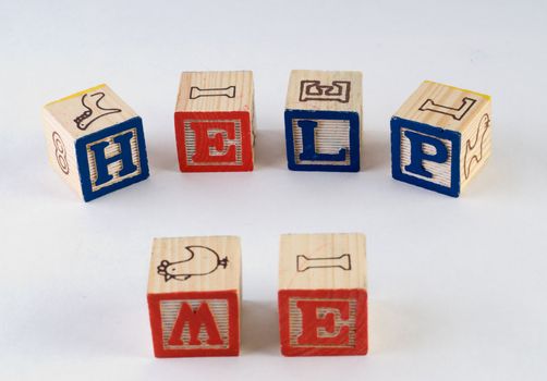 The words help me, spelled using wooden baby blocks