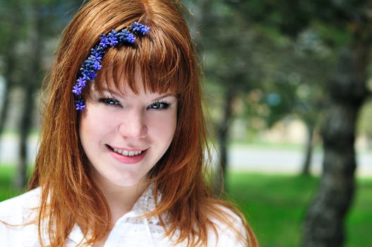 redheaded girl in the spring forest with flowers in her hair