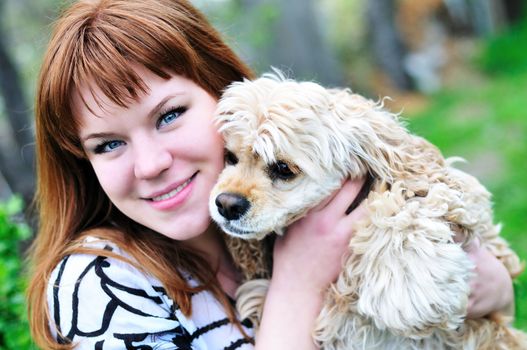 redheaded pretty girl hugging her dog on the meadow
