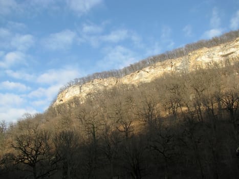 Clouds; rocks; a relief; a landscape; a hill