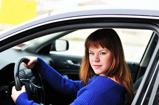 redheaded pretty teen girl  driving a car