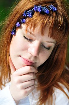 redheaded girl in the spring forest with flowers in her hair

