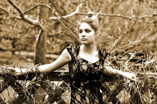 tree-bound attractive girl in sepia standing near the wall